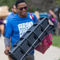 Gentleman carrying black storage unit in for student